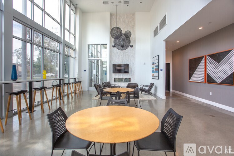 A large room with a round table and chairs in the center.
