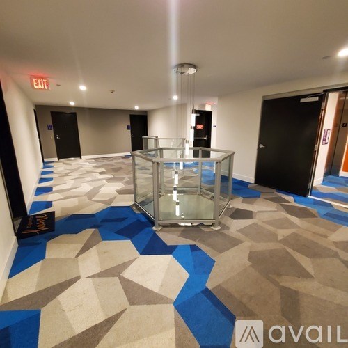 A hallway with a blue and white tiled floor and a glass display case in the middle.