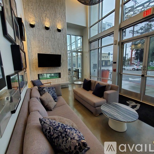 A living room with a long couch and a flat screen TV mounted on the wall.