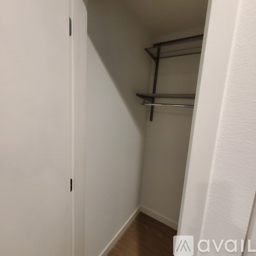 A white closet with a shelf and a door.
