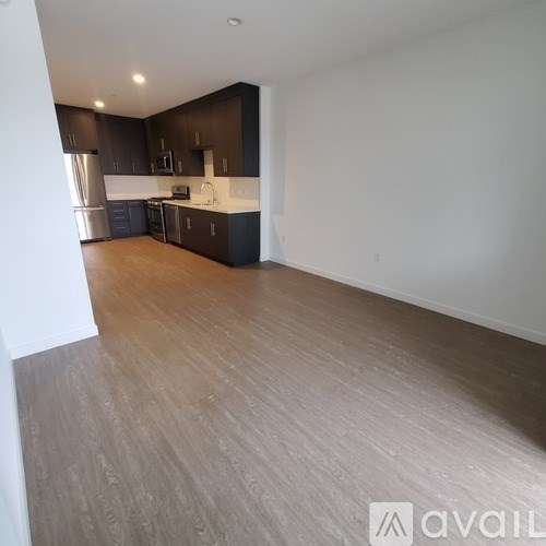 A kitchen with dark brown cabinets and a wooden floor.