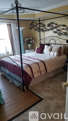 A bedroom with a four poster bed and a window.