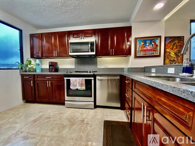 A kitchen with brown cabinets and a stainless steel oven.