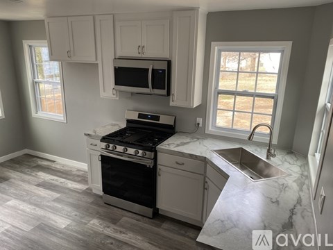 A kitchen with a black stove top oven and a marble counter top.