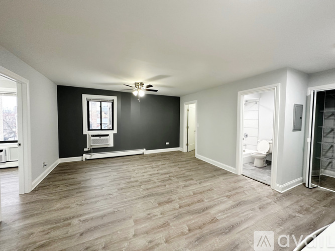 A spacious room with a ceiling fan and a window.