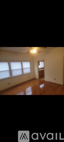 A room with wooden floors and a ceiling fan.