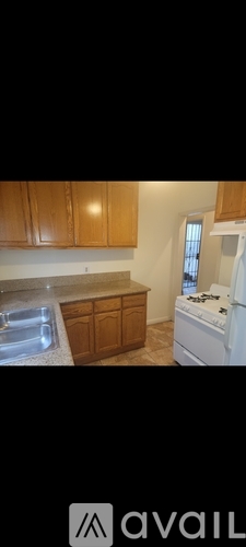 A kitchen with wooden cabinets and a white dishwasher.