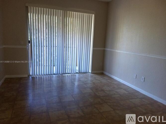 A room with a tiled floor and a sliding door with blinds.