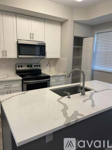 A kitchen with white cabinets and a granite countertop.