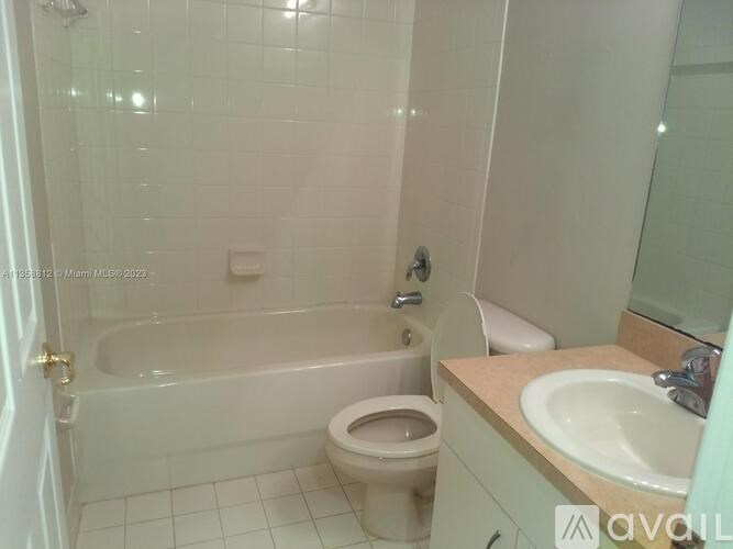 A white bathroom with a toilet, sink, and bathtub.