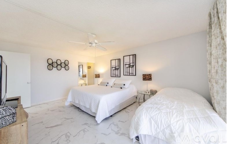 A bedroom with two beds and a ceiling fan.