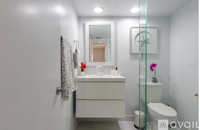 A white bathroom with a toilet, sink, and mirror.