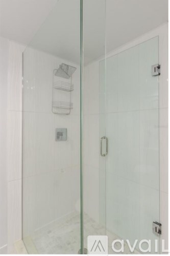 A glass shower door with a handle and a towel rack.