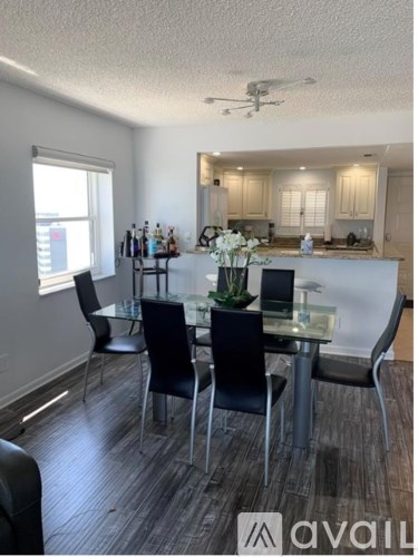 A modern dining room with a glass table and chairs.