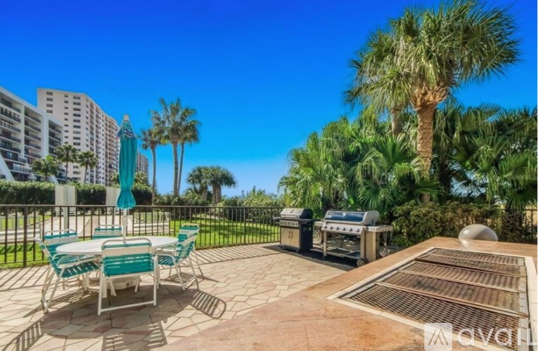 A patio with a table and chairs overlooking a cityscape.