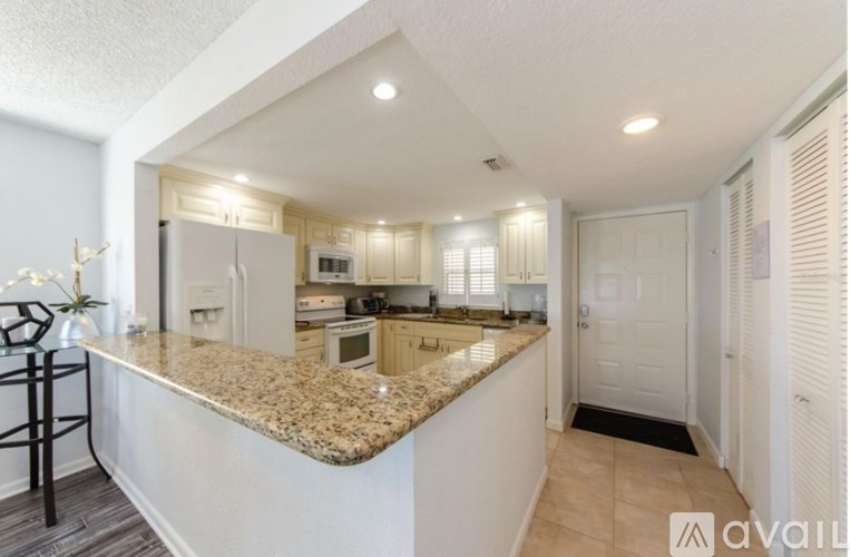 A kitchen with granite countertops and white cabinets.