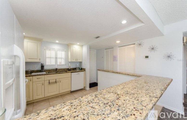 A kitchen with granite countertops and white appliances.