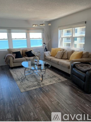 A living room with a glass table and a couch.