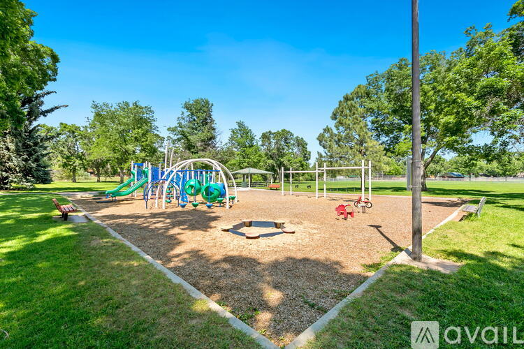 A playground with a slide, swings, and a seesaw.