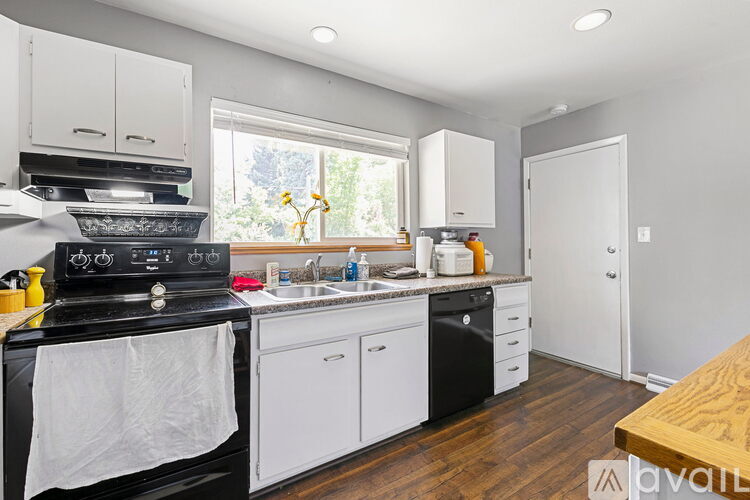 A kitchen with black appliances and white cabinets.
