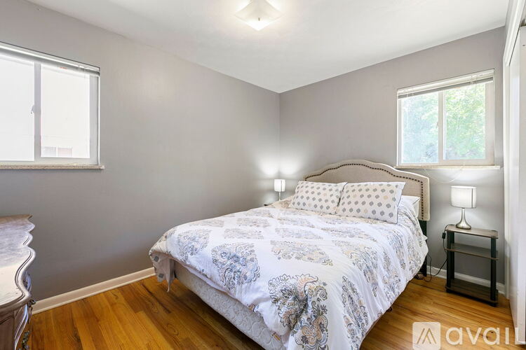 A bedroom with a bed, nightstand, and window.