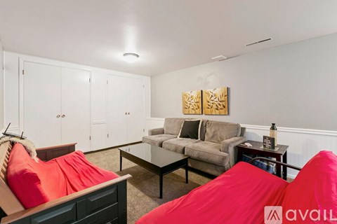 A living room with a couch, chair, and a painting on the wall.