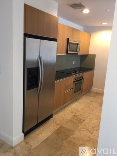 A kitchen with a refrigerator, microwave, oven and countertop.