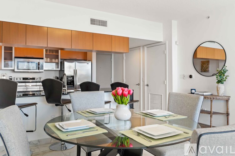 A modern dining room with a glass table set for four.