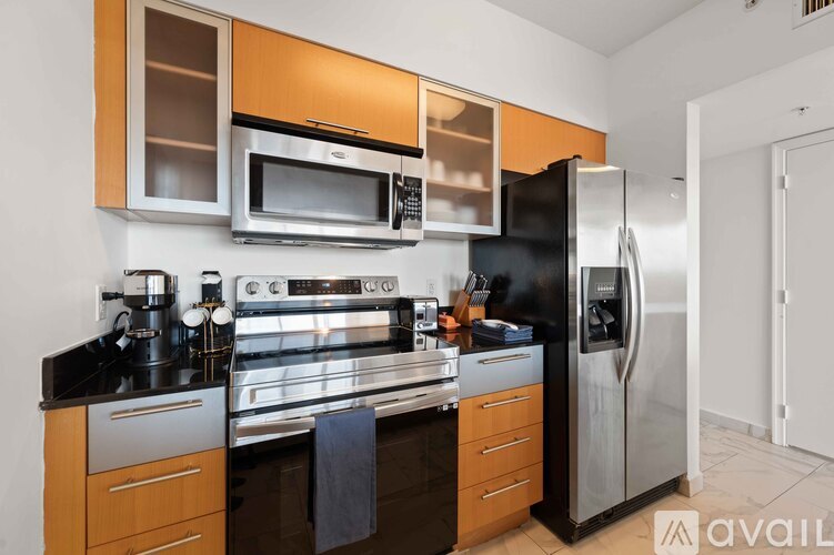 A kitchen with a black refrigerator and stainless steel appliances.