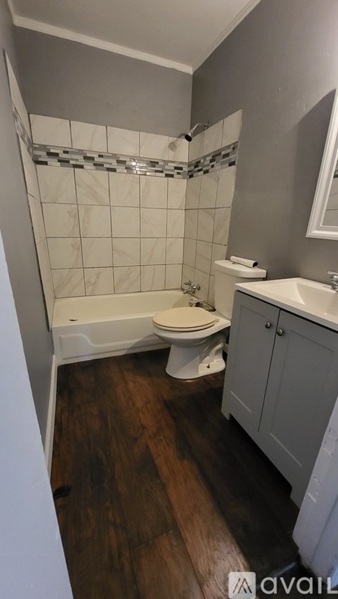 A bathroom with a white toilet, sink, and bathtub.