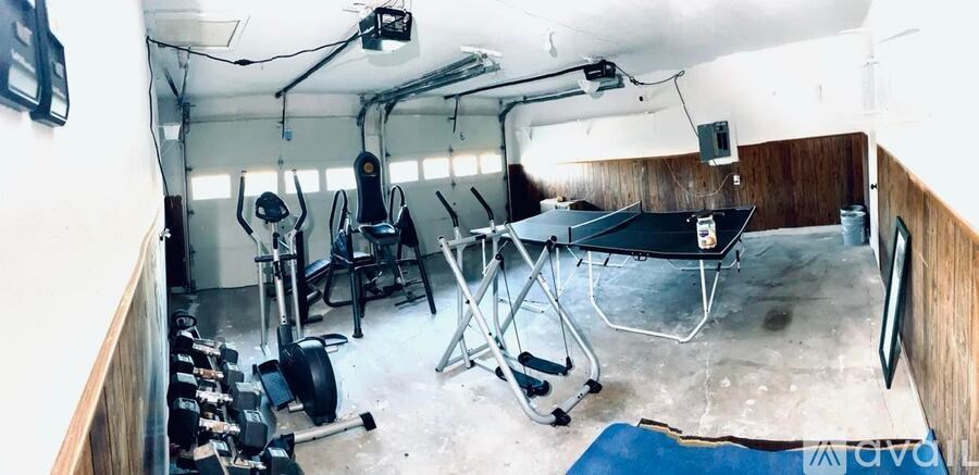 A gym with a variety of equipment including weights and a bench press.