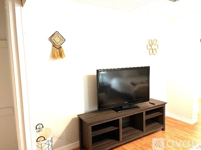 A black television on a wooden stand in a room.