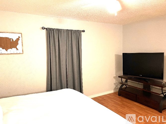 A bedroom with a bed, a television, and a map of the United States on the wall.