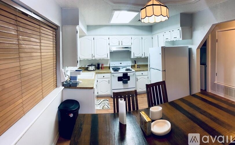 A modern kitchen with a dining table set for two.