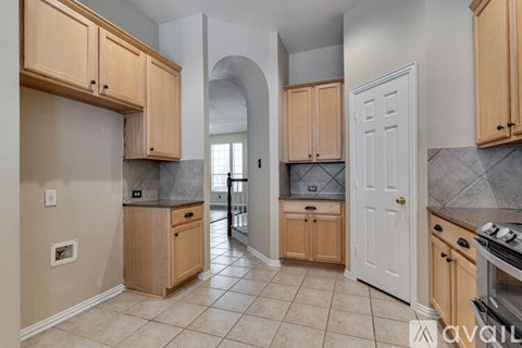 A kitchen with wooden cabinets and a white door.