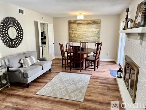 A living room with a grey couch and a wooden dining table.