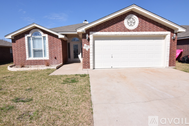 A brick house with a white garage door and a window on the left side.