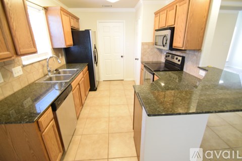 A kitchen with wooden cabinets and black appliances.