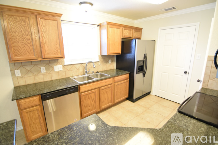 A kitchen with wooden cabinets and black granite countertops.