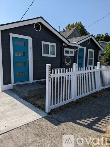 A small house with a white picket fence in front.