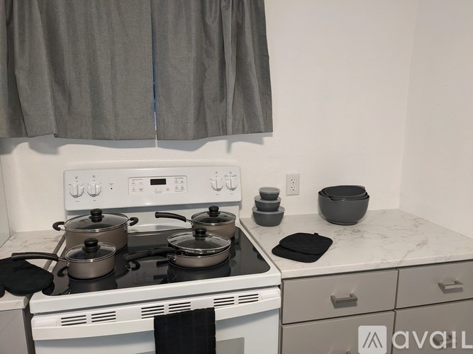 A white stove top with four pots on it.
