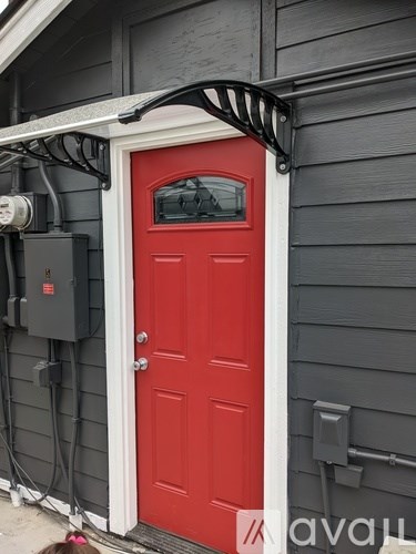 A red door with a black metal awning above it.