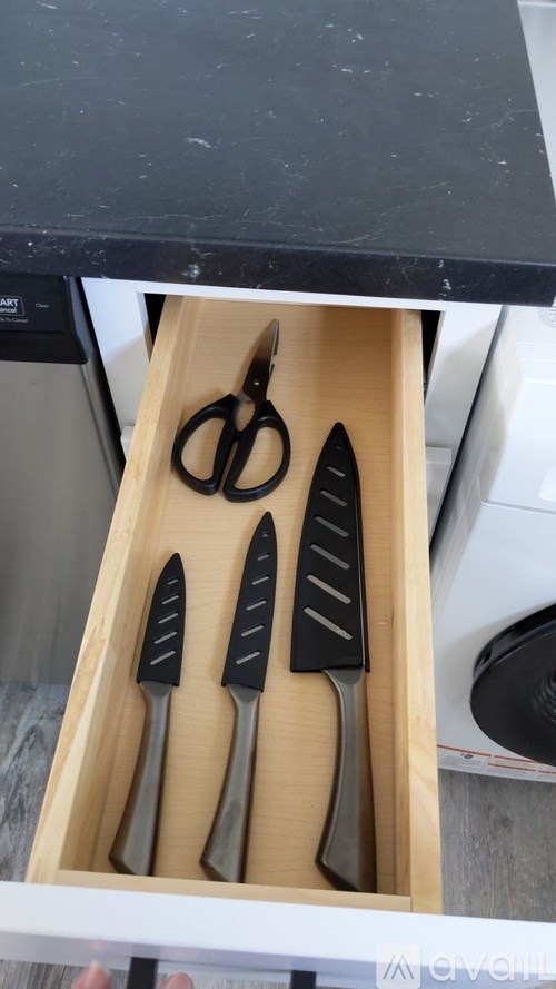 A set of three knives and a pair of scissors in a wooden holder.