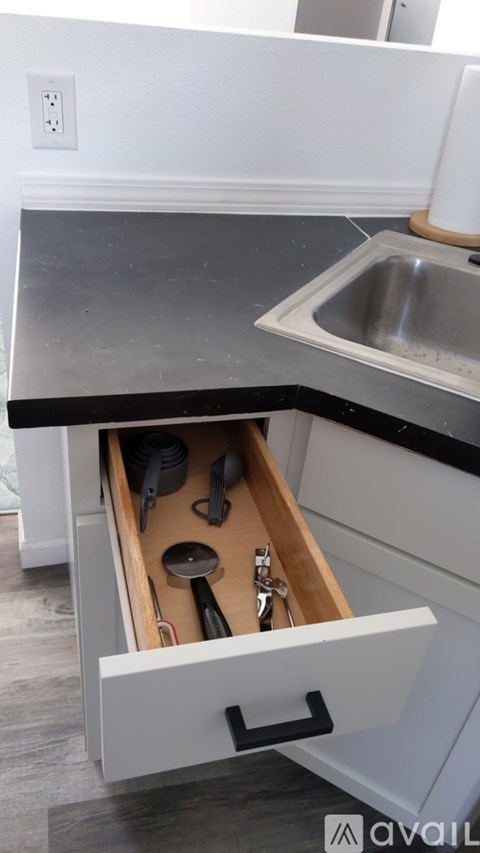 A kitchen drawer with utensils in it.