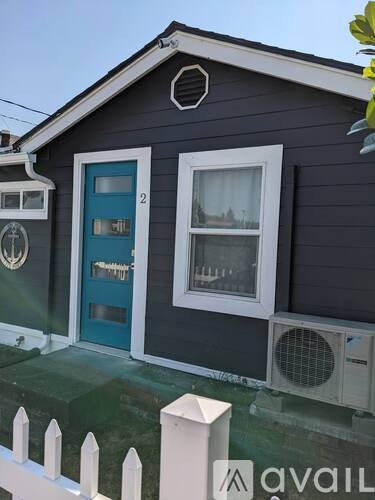 A house with a blue door and a white fence.