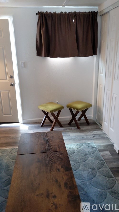 Two yellow chairs sit under a brown curtain.