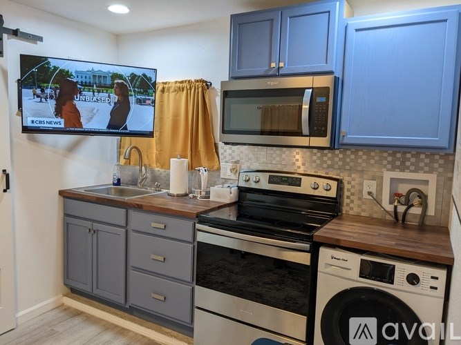 A kitchen with a TV displaying a news program.