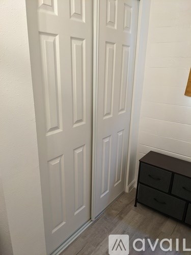 A white door with a black drawer in front of it.