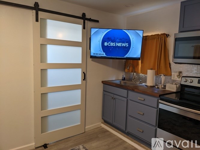 A CBS News channel is being broadcast on a television in a modern kitchen.