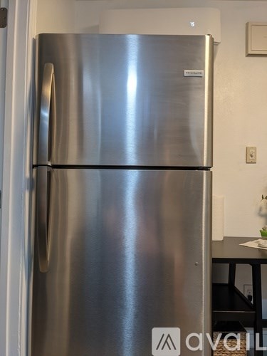 A stainless steel refrigerator with a logo on the door.